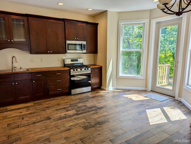 kitchen with a notable chandelier, dark hardwood / wood-style flooring, stainless steel appliances, and sink