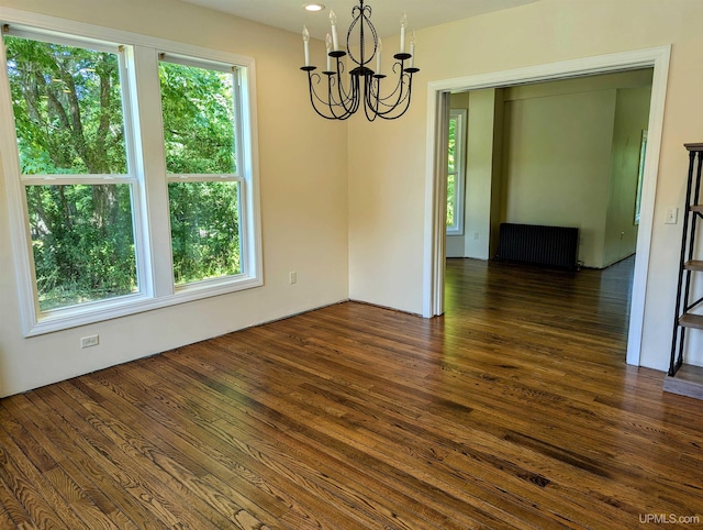 unfurnished room with a notable chandelier, dark hardwood / wood-style floors, and a wealth of natural light