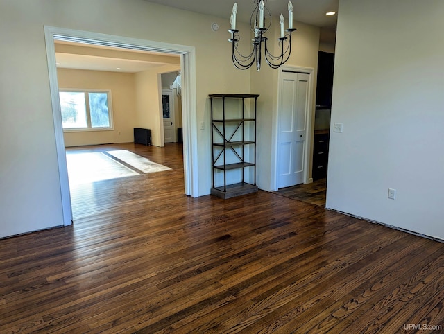 unfurnished dining area featuring dark hardwood / wood-style flooring and an inviting chandelier