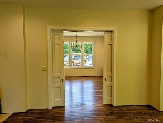 interior space with dark wood-type flooring and an inviting chandelier