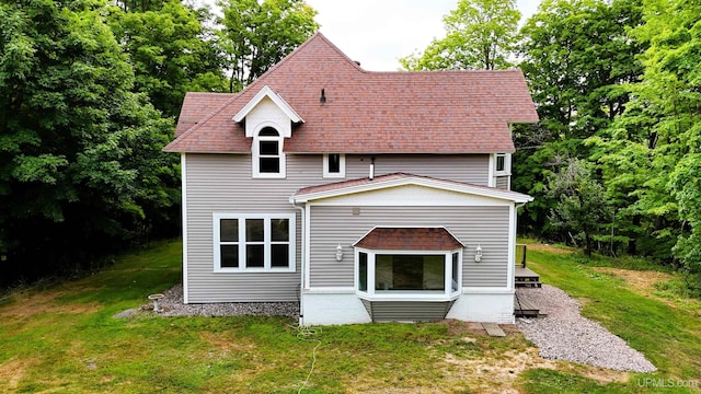 rear view of property featuring a lawn