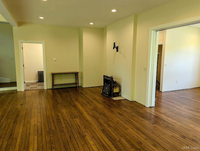 unfurnished living room with radiator and dark wood-type flooring