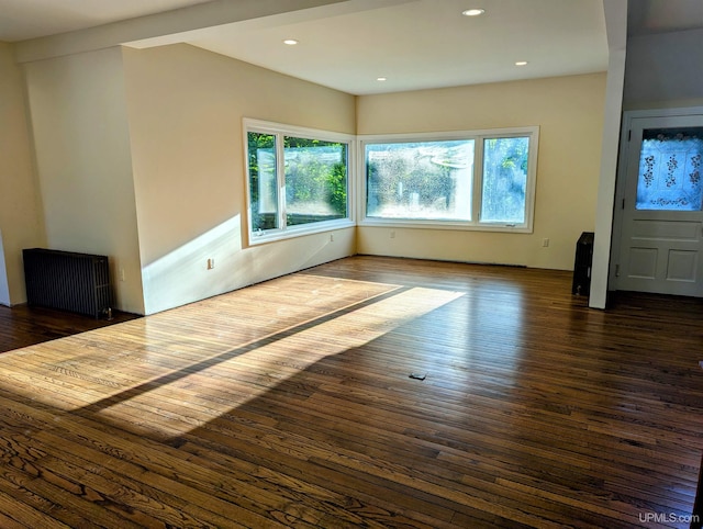 unfurnished living room with radiator and dark wood-type flooring