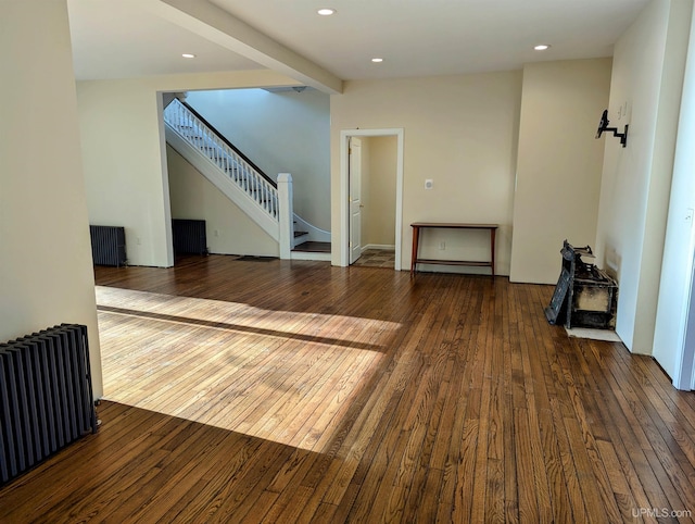 unfurnished living room featuring radiator, dark wood-type flooring, and baseboard heating