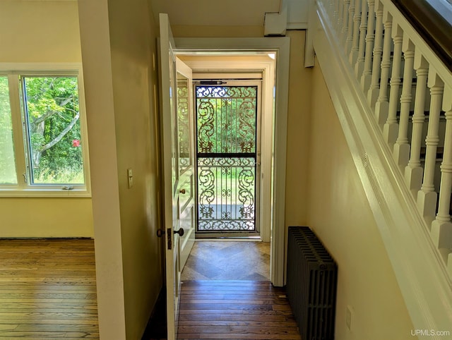 doorway with hardwood / wood-style flooring and radiator heating unit