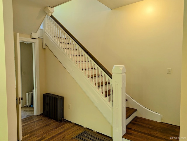 staircase with radiator and hardwood / wood-style floors