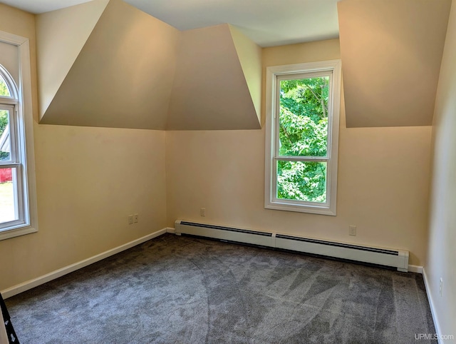 additional living space with baseboard heating, a wealth of natural light, lofted ceiling, and dark carpet