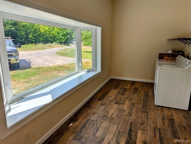 washroom featuring washing machine and dryer, dark hardwood / wood-style flooring, and a wealth of natural light