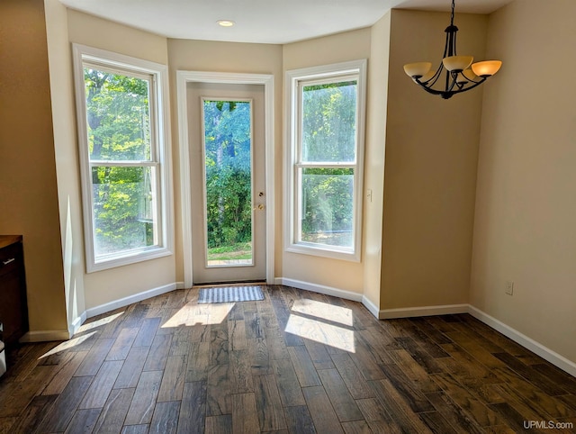 doorway featuring an inviting chandelier and dark hardwood / wood-style floors