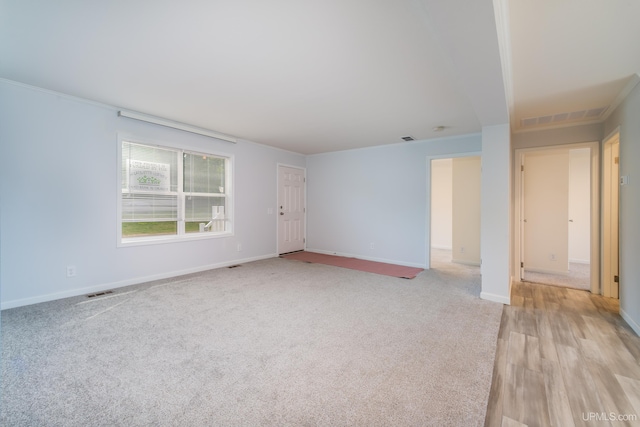 unfurnished room featuring visible vents, baseboards, and light colored carpet