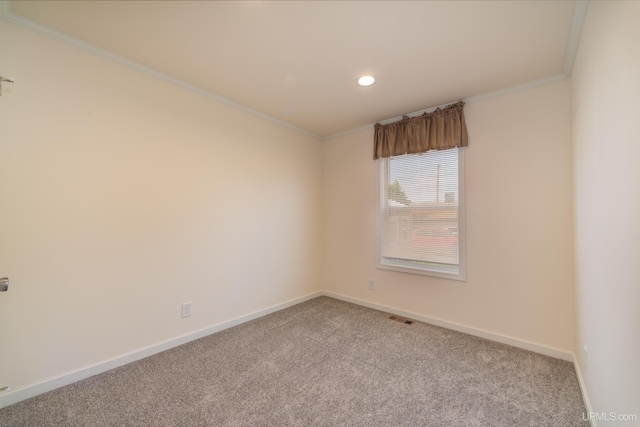 carpeted empty room featuring visible vents, baseboards, and ornamental molding