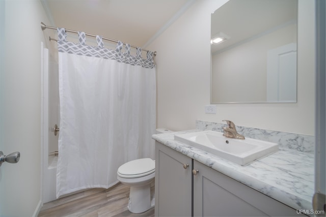 full bath featuring shower / tub combo with curtain, toilet, wood finished floors, crown molding, and vanity