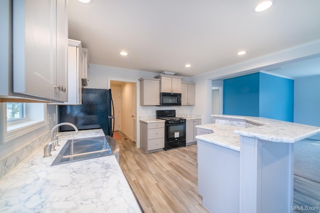 kitchen with gray cabinetry, sink, light hardwood / wood-style flooring, black appliances, and ornamental molding