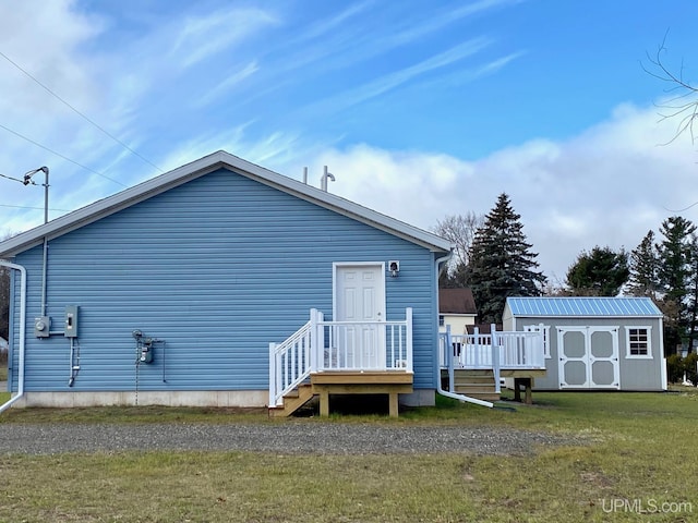 back of house featuring a lawn, a shed, and a deck