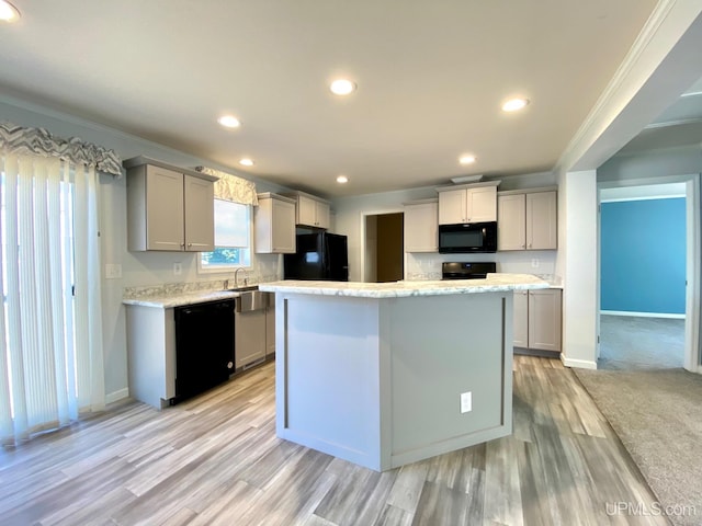 kitchen featuring a center island, gray cabinets, ornamental molding, and black appliances