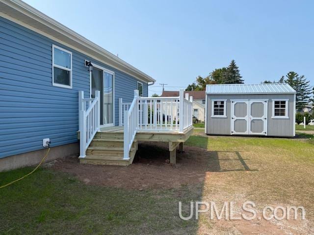 view of yard with an outbuilding, a wooden deck, and a storage shed