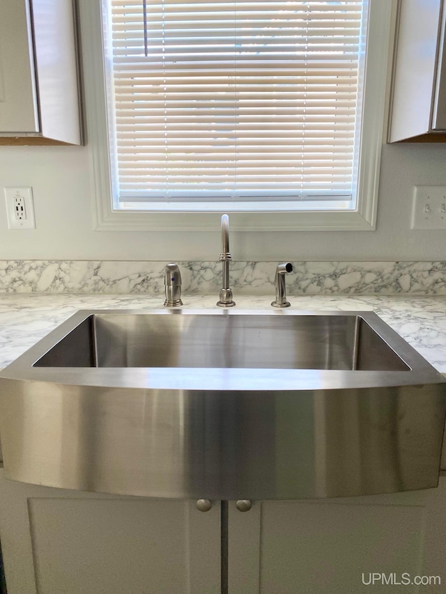 interior details with light stone countertops and sink