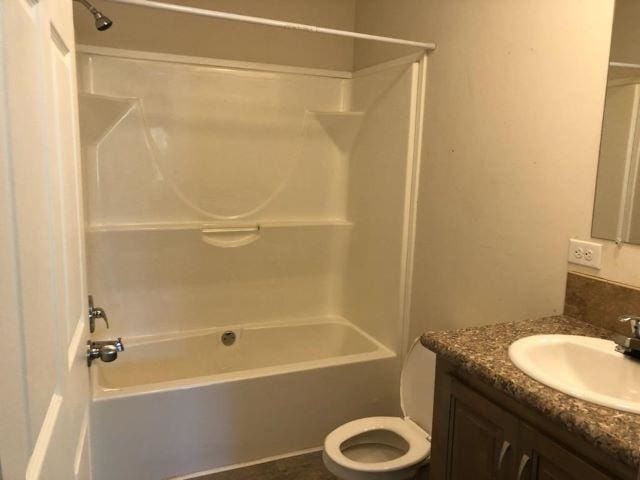 bathroom featuring toilet, vanity, and shower / bathtub combination