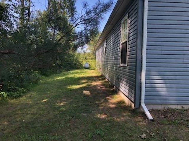 view of side of home with a lawn