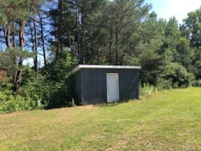 view of outbuilding featuring a lawn