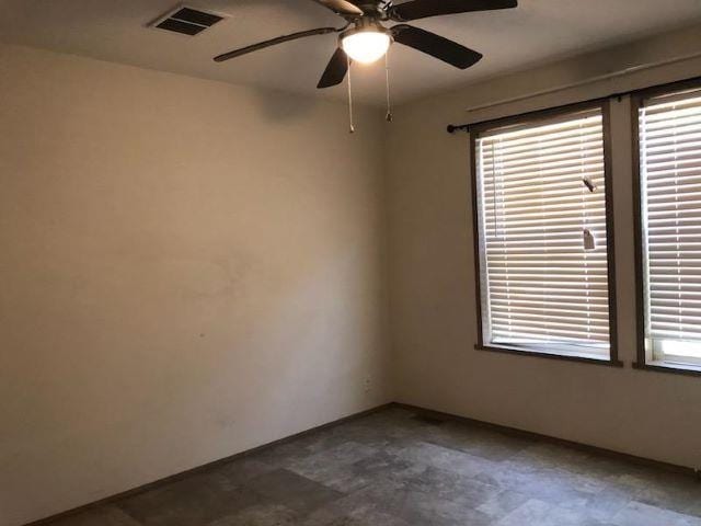 spare room with a healthy amount of sunlight, a ceiling fan, and visible vents