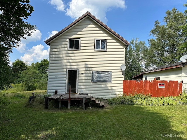 rear view of house featuring a lawn