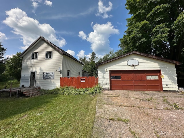 view of front of house with a front yard, a garage, and an outdoor structure