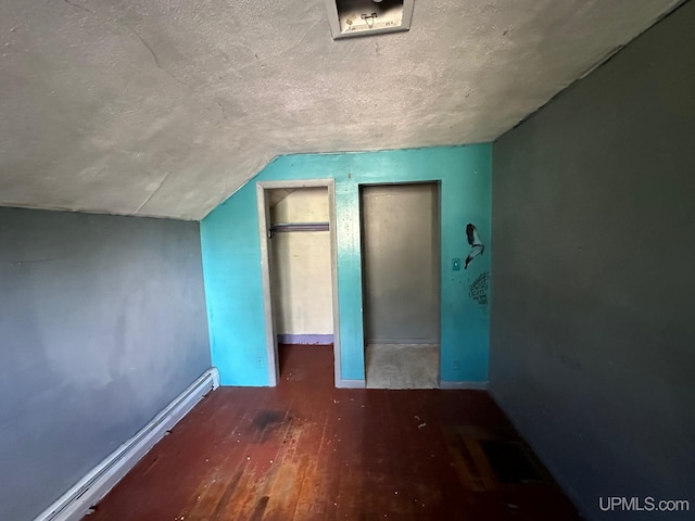 additional living space featuring a textured ceiling, hardwood / wood-style floors, and vaulted ceiling