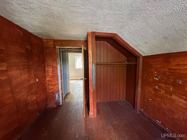 additional living space with a textured ceiling and hardwood / wood-style floors