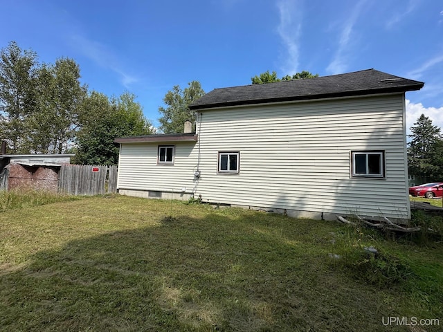 rear view of property featuring a lawn