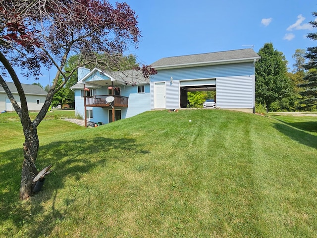 back of house featuring a balcony and a yard