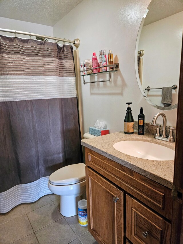 bathroom featuring tile patterned floors, a textured ceiling, vanity, and toilet