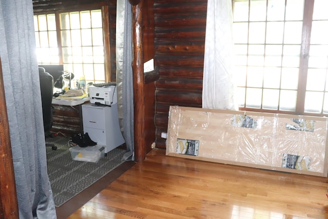 interior space with wood-type flooring and log walls