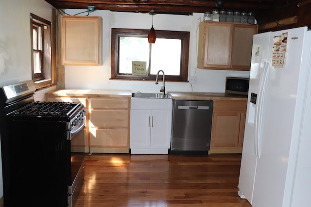 kitchen with dark hardwood / wood-style flooring, pendant lighting, light brown cabinets, stainless steel appliances, and sink