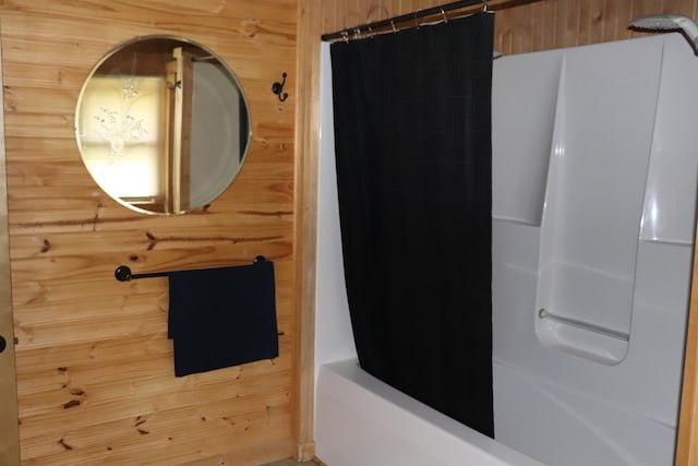 bathroom with wooden walls and shower / bath combination with curtain