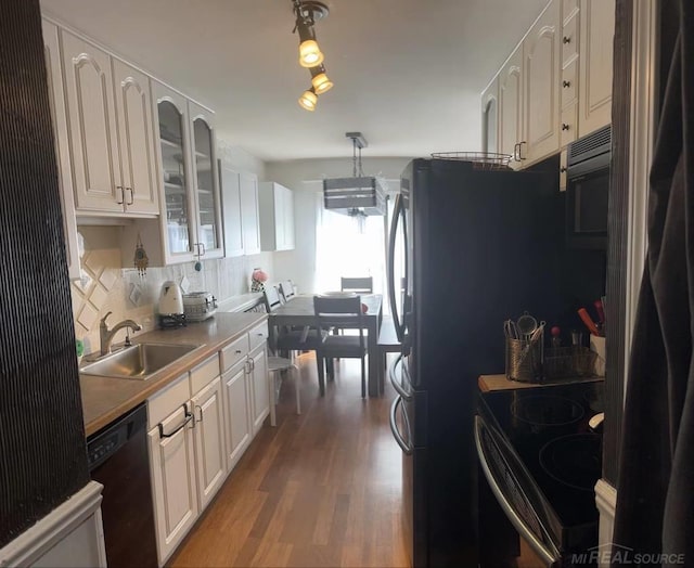 kitchen featuring stove, dishwasher, wood-type flooring, sink, and white cabinetry