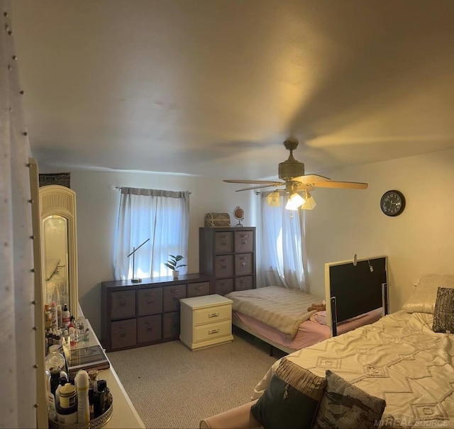 bedroom featuring ceiling fan, multiple windows, and carpet