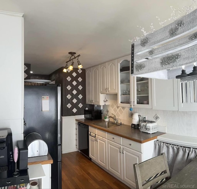 kitchen with dark wood-type flooring, ventilation hood, sink, backsplash, and black appliances