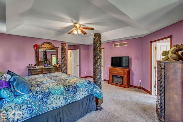 carpeted bedroom featuring ceiling fan and a tray ceiling