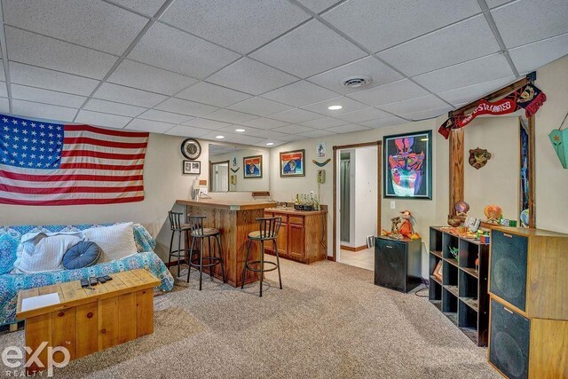 bar featuring light carpet and a drop ceiling