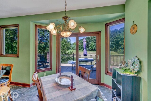 dining room featuring a chandelier and tile patterned flooring