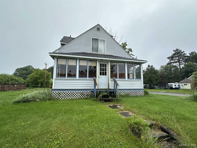 exterior space featuring a yard and a sunroom