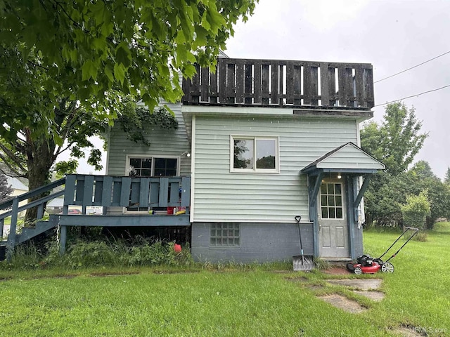 rear view of property with a wooden deck and a yard