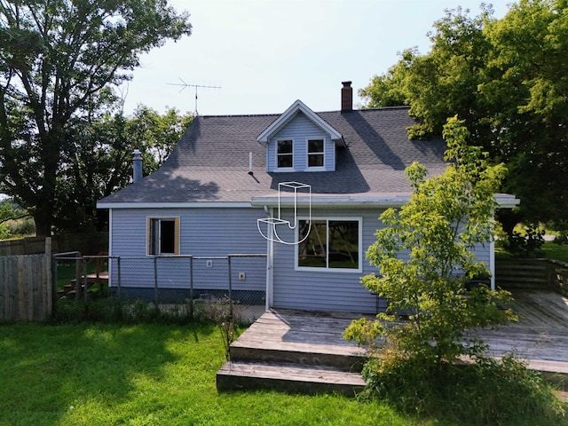 rear view of house featuring a lawn and a deck