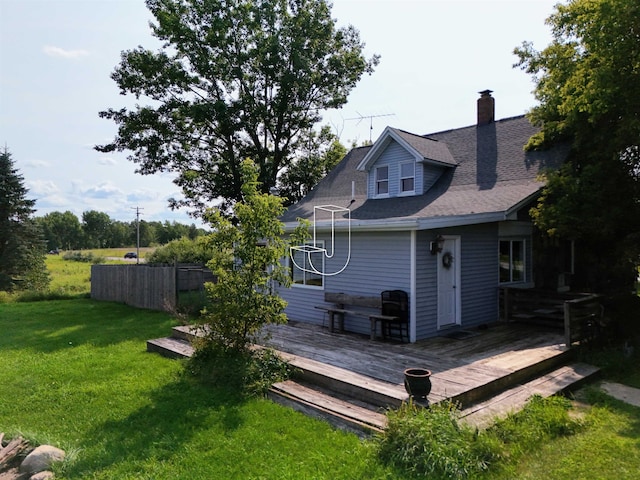 back of property featuring a wooden deck and a lawn