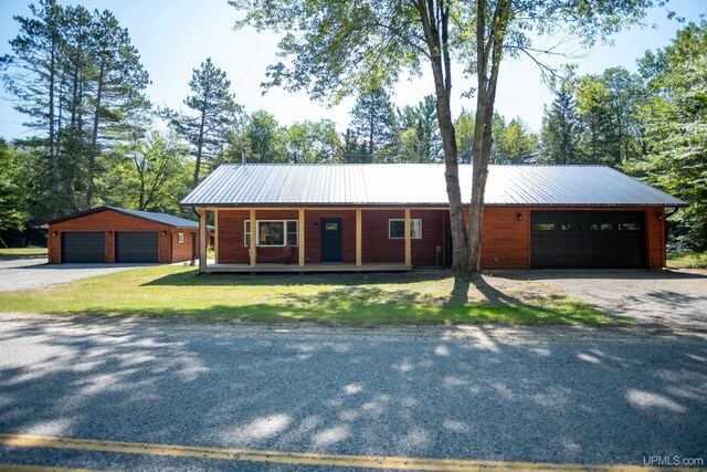 single story home featuring an outbuilding and a garage