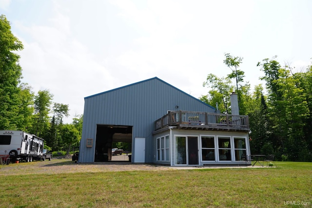 rear view of house featuring a lawn and an outbuilding