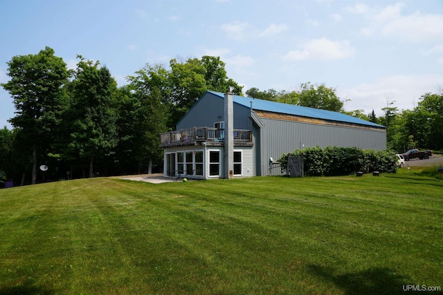 back of property featuring a lawn, a balcony, and a patio area