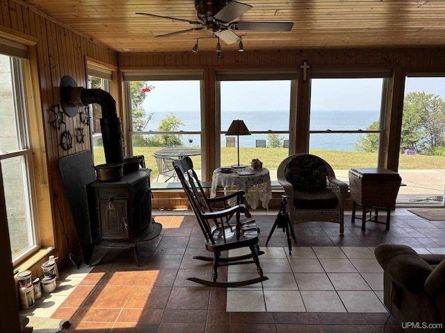 14998 N Superior Rd, Houghton, MI 49931 - sunroom / solarium featuring a water view, a wood stove, wood ceiling, plenty of natural light, and wood walls