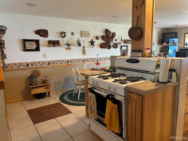 kitchen featuring light tile patterned floors and white gas stove